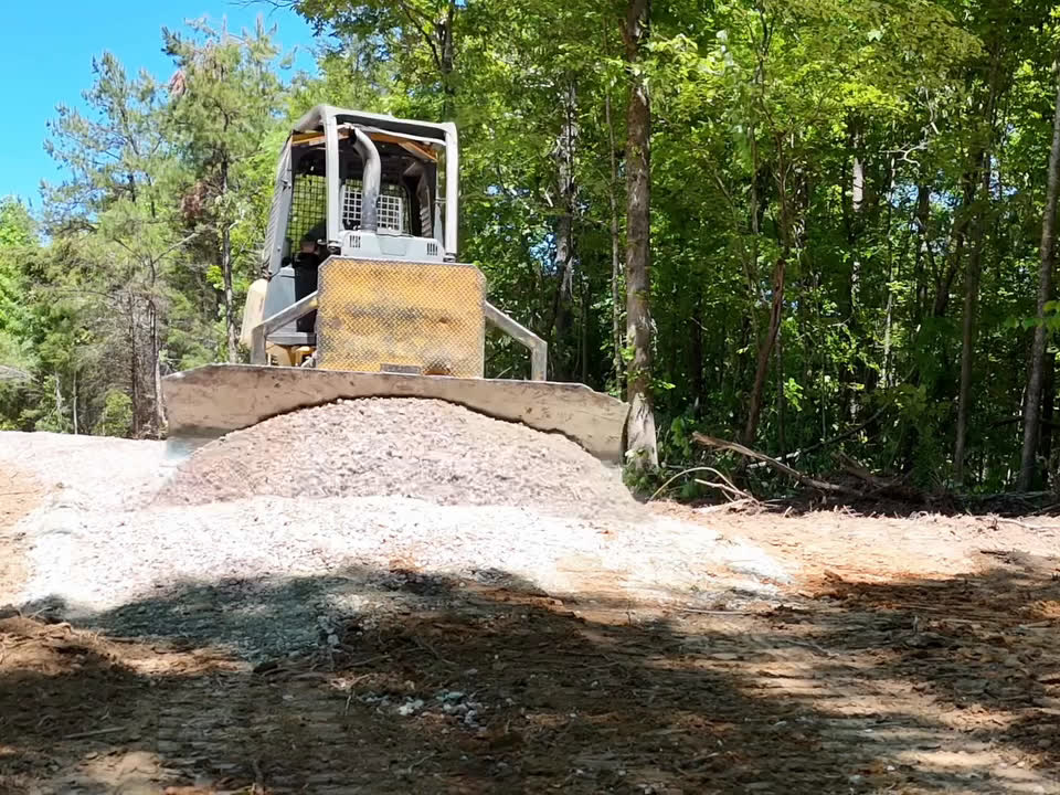 A dozer spreading a fresh load of gravel for a drive.